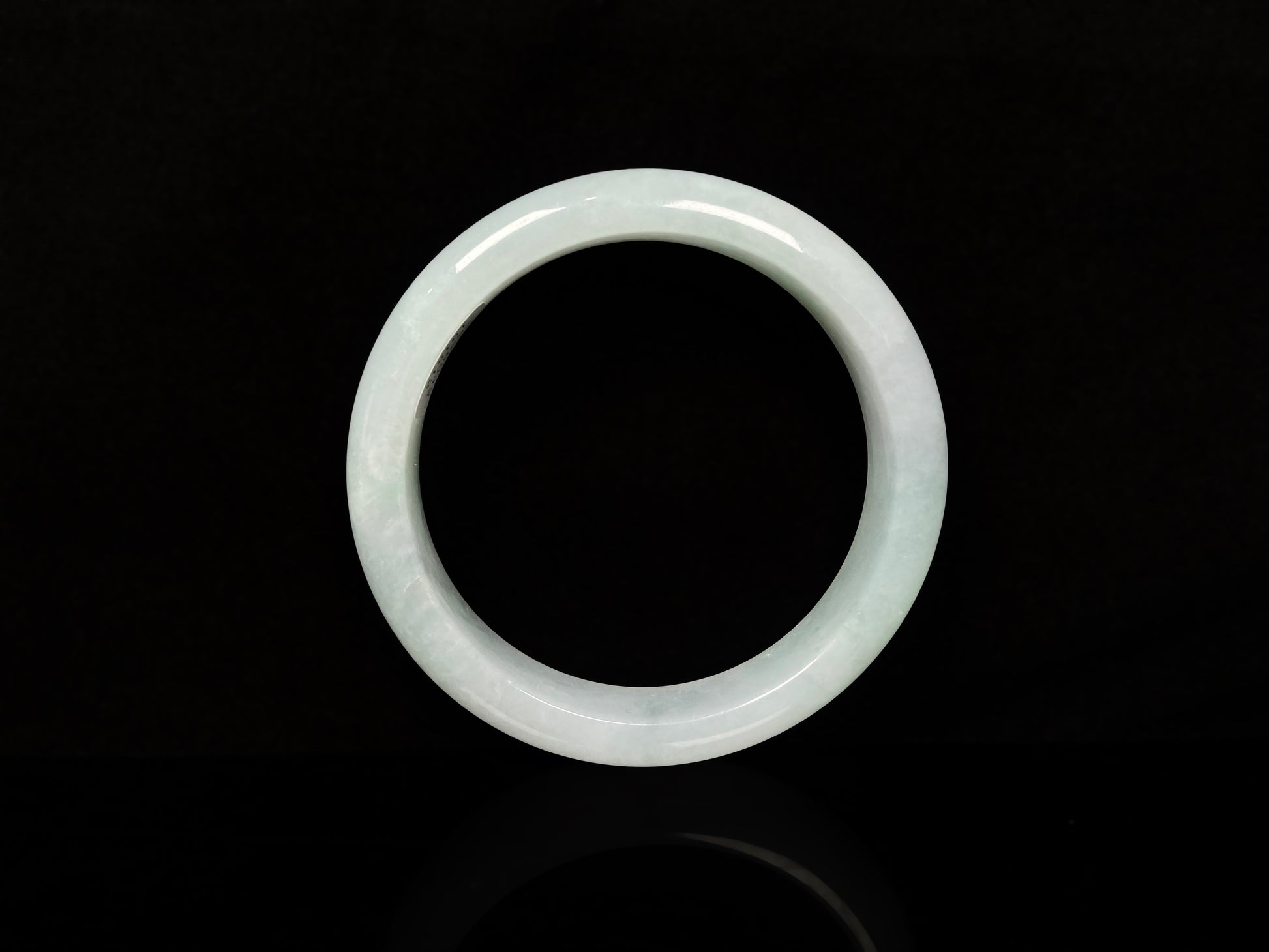 A pale white green mist jadeite bangle.