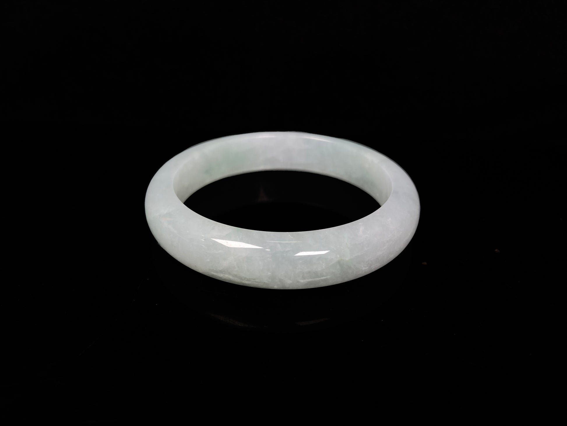 A pale white green mist jadeite bangle.