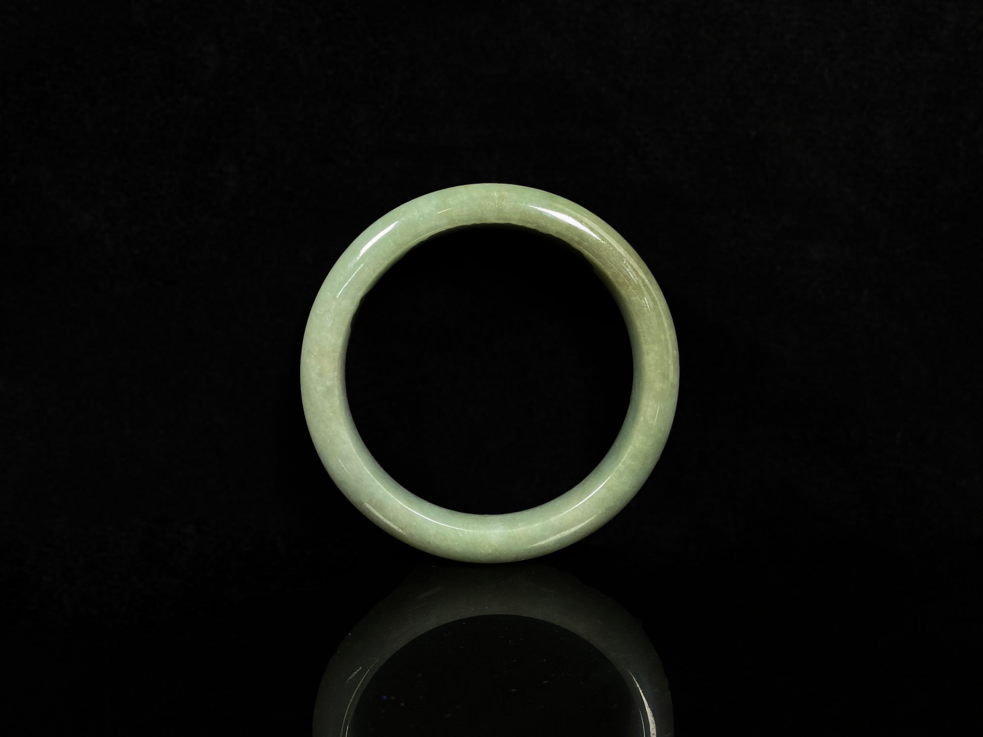 A light green base with warm golden hues jadeite bangle.