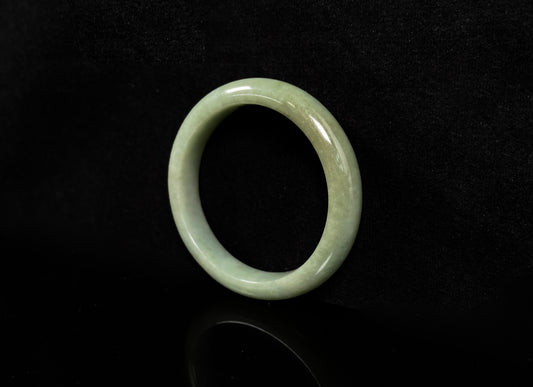 A light green base with warm golden hues jadeite bangle.