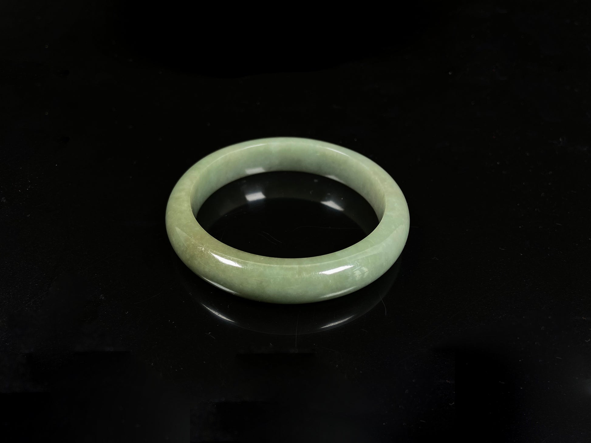 A light green base with warm golden hues jadeite bangle.