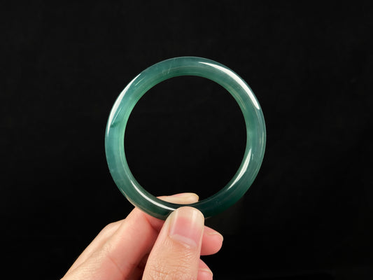 A sleek deep aqua green jadeite bangle.