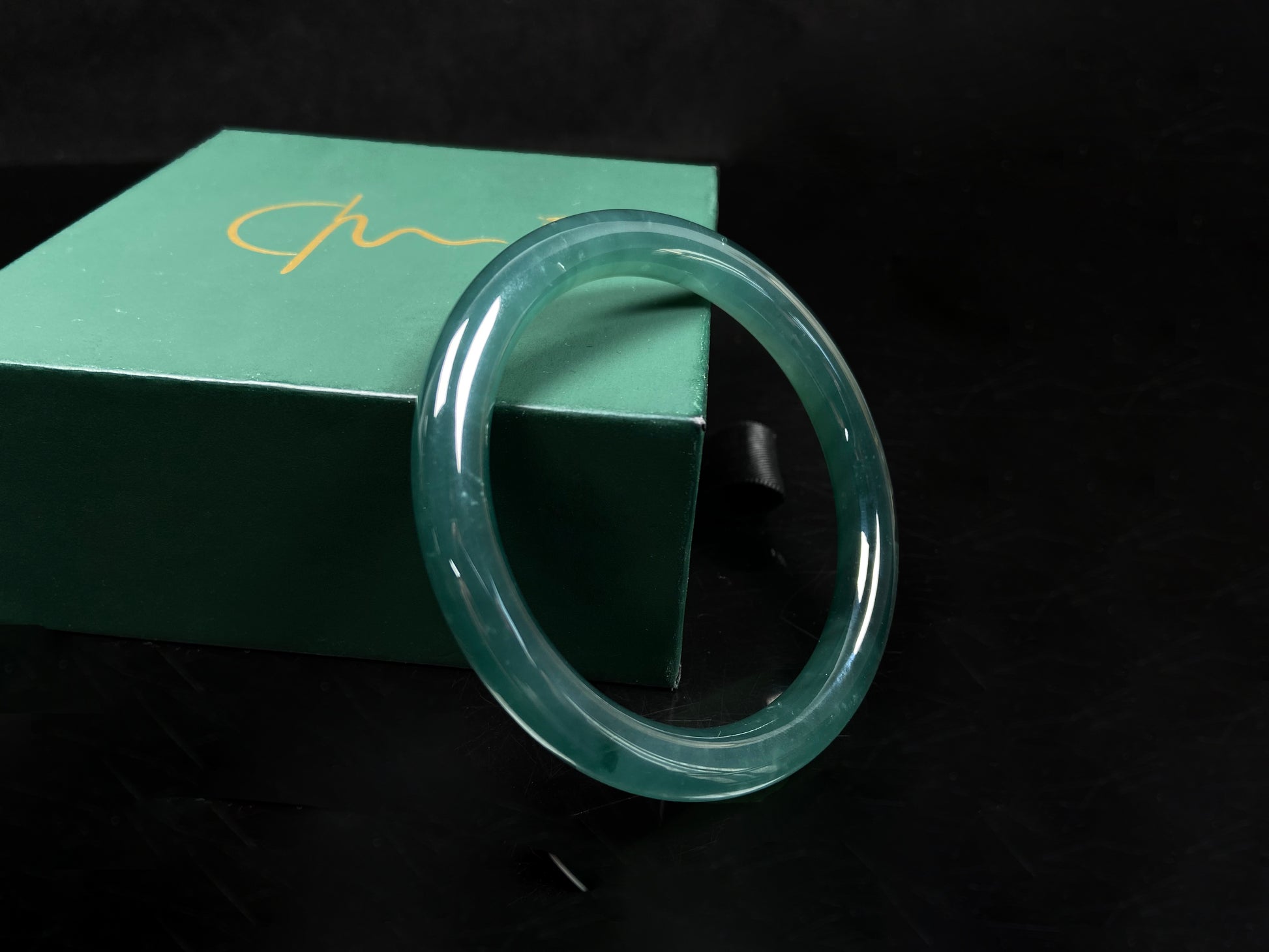 A sleek deep aqua green jadeite bangle.
