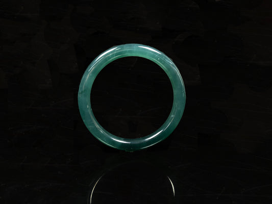 A sleek deep aqua green jadeite bangle.