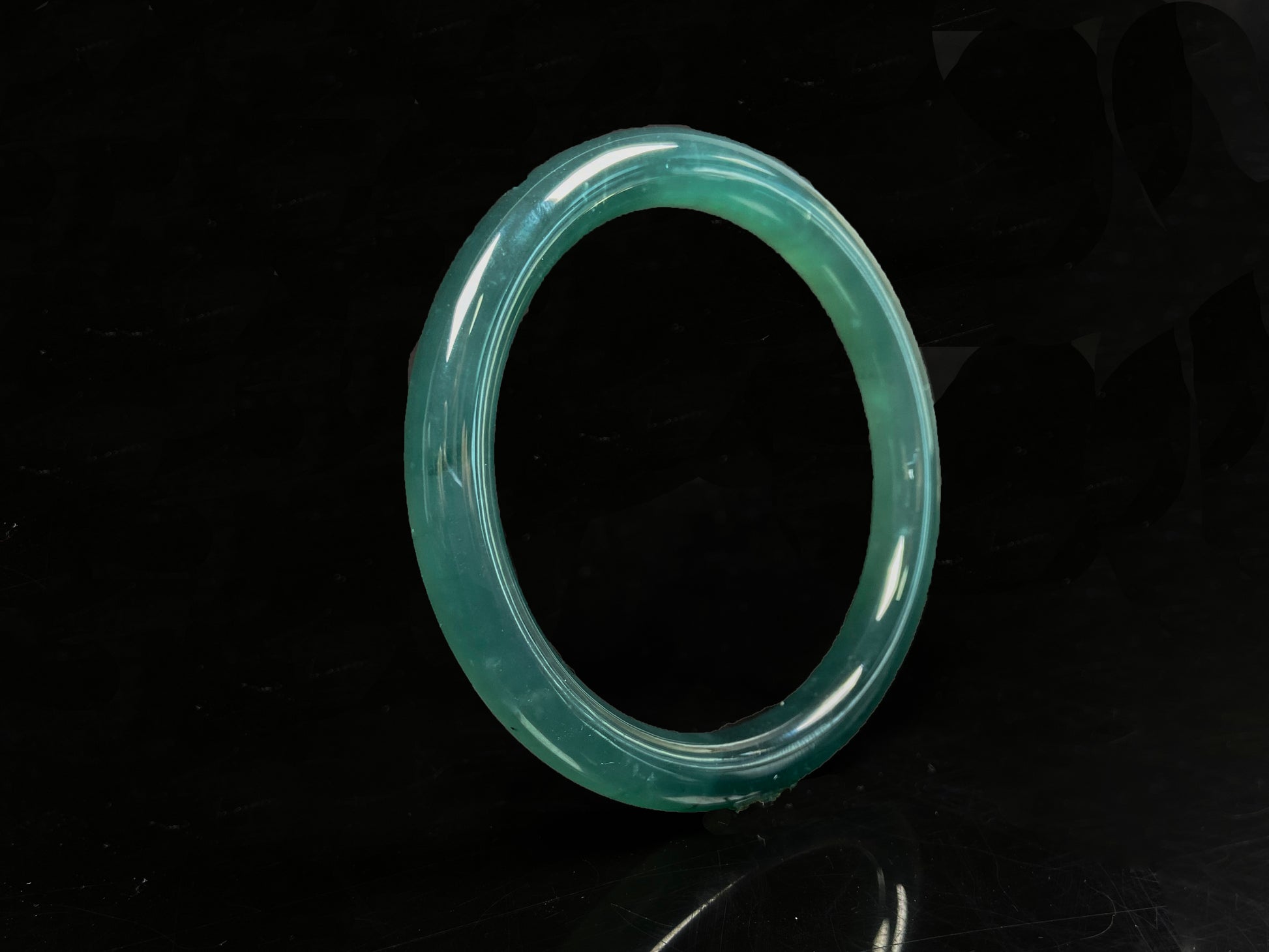 A sleek deep aqua green jadeite bangle.