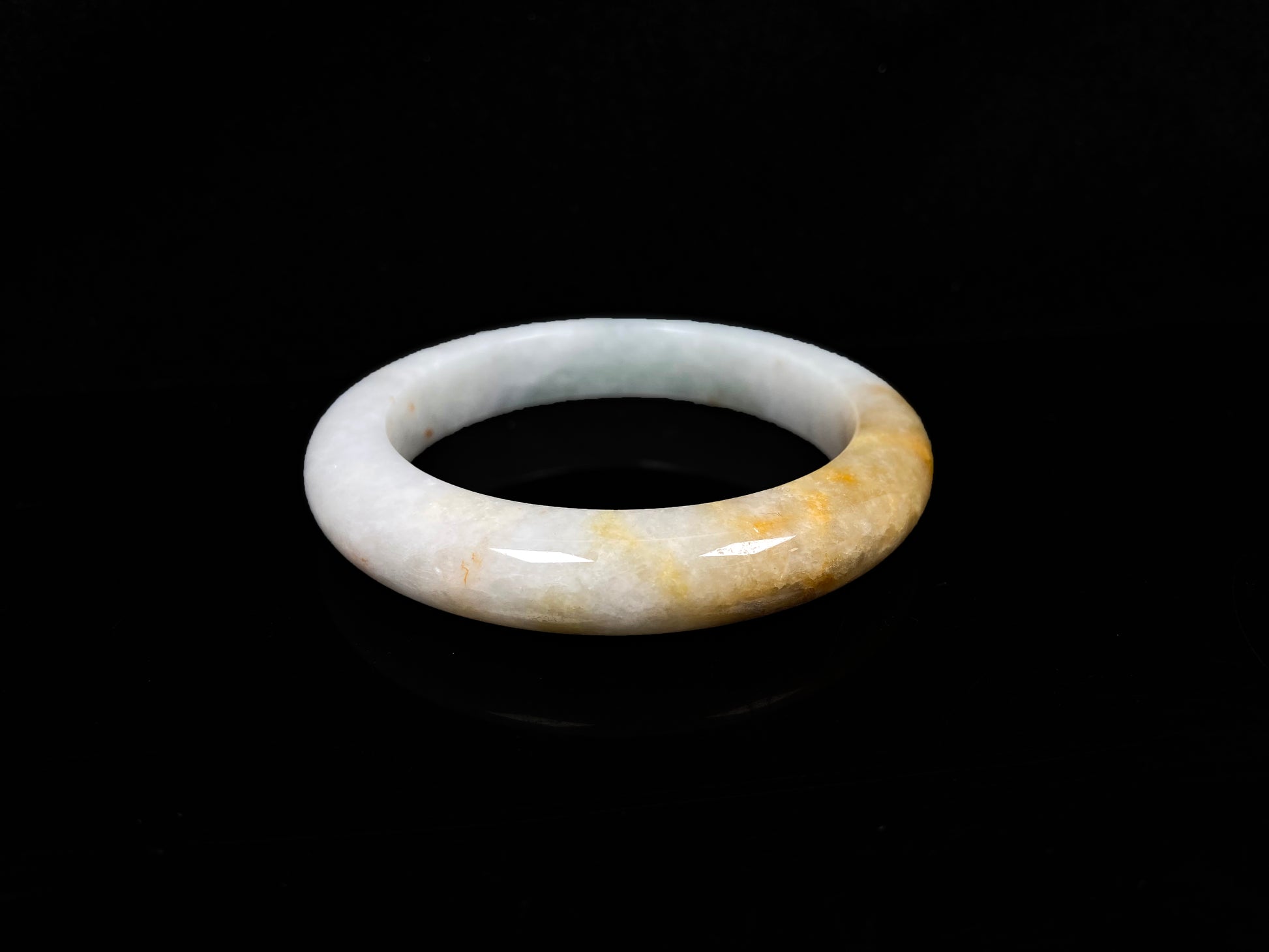 A creamy white with green and honey yellow  jadeite bangle.