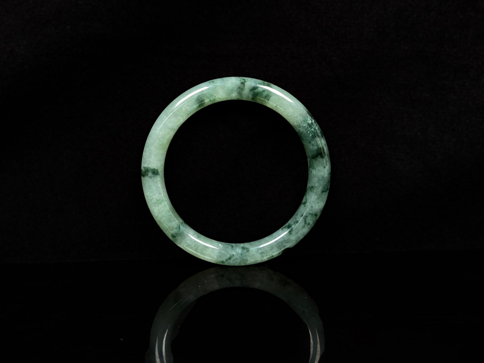 A waxy icy with moss green jadeite bangle.
