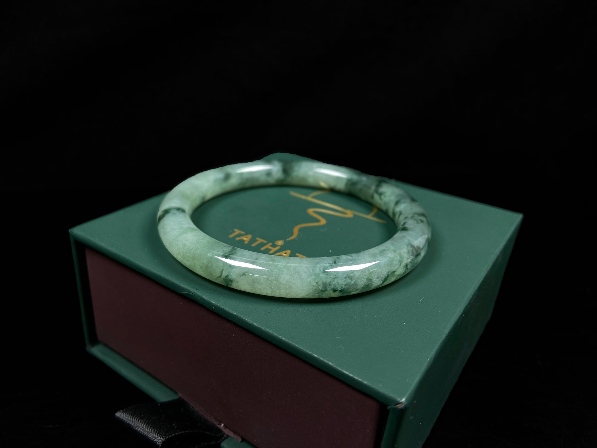 A waxy icy with moss green jadeite bangle.
