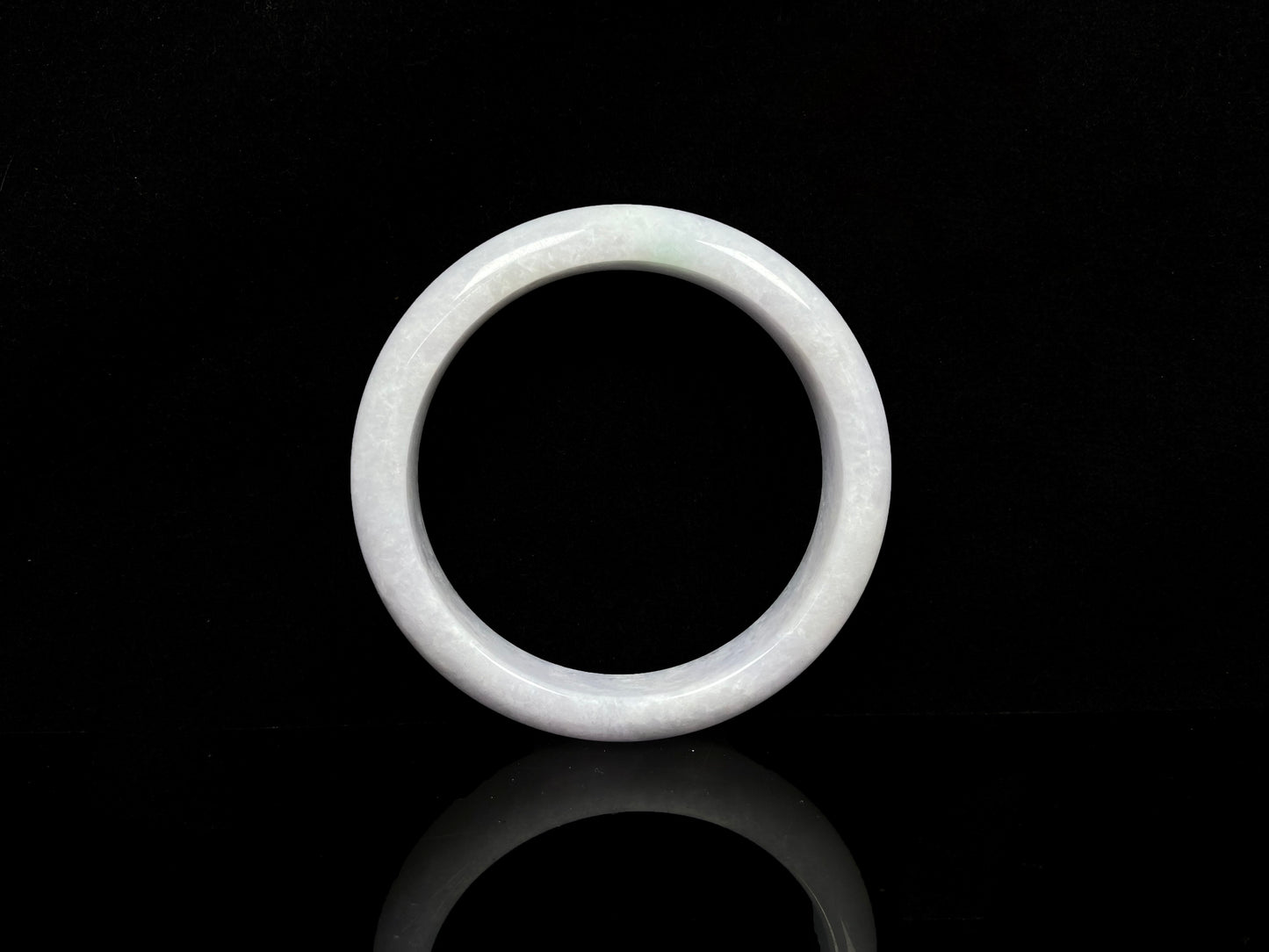 A cloudy white with pale green streaks jadeite bangle.
