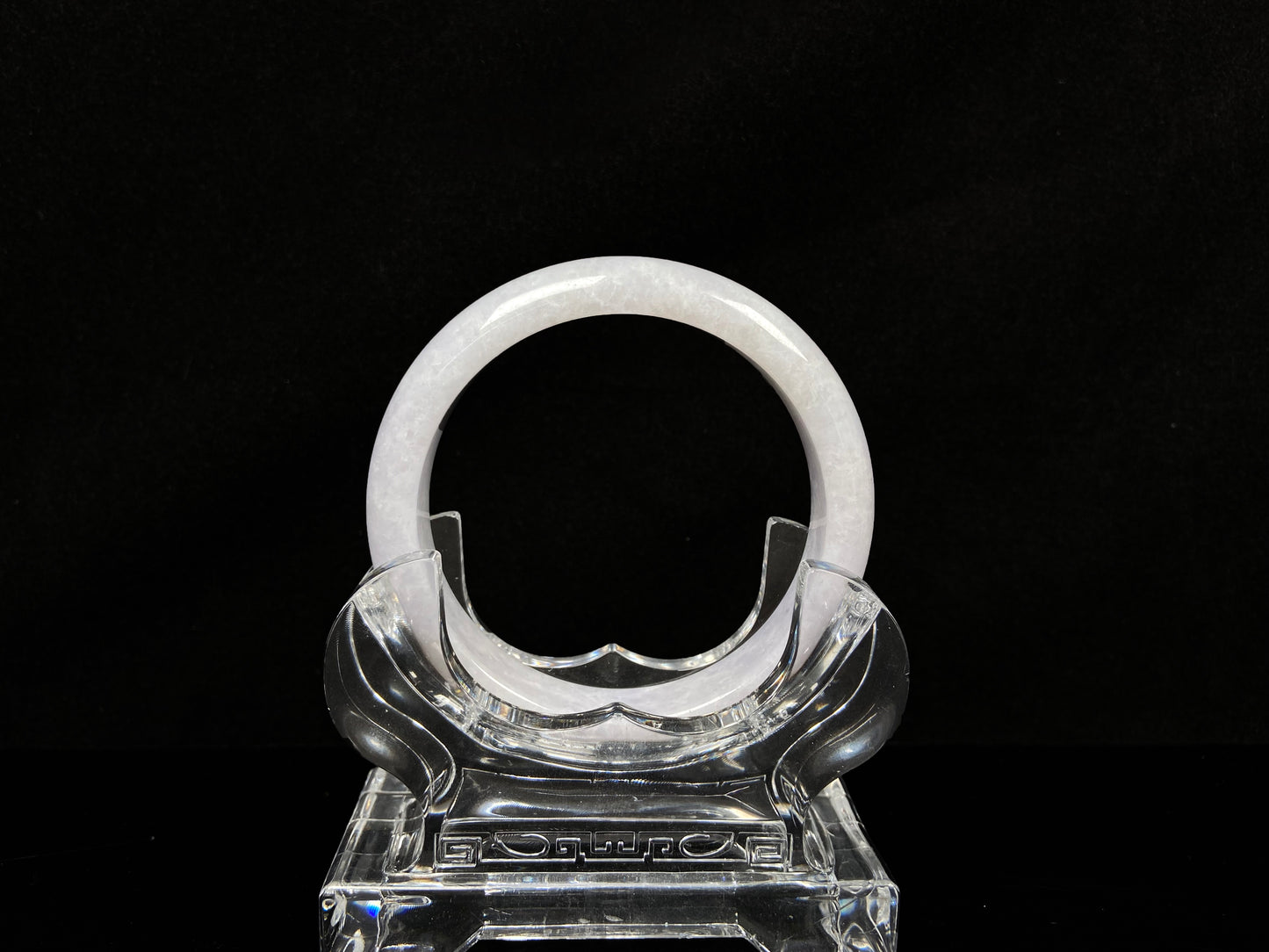 A cloudy white with pale green streaks jadeite bangle.