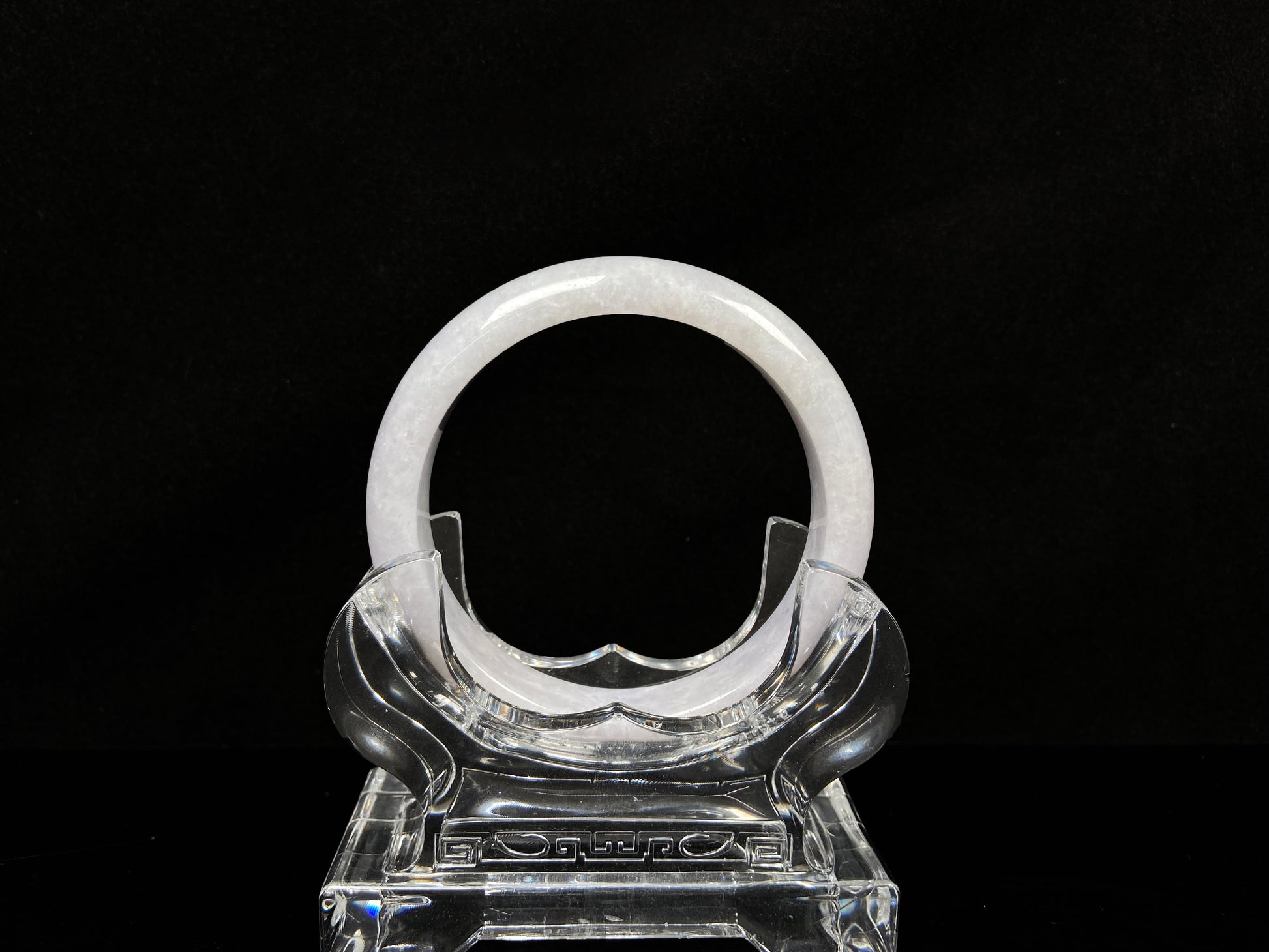 A cloudy white with pale green streaks jadeite bangle.