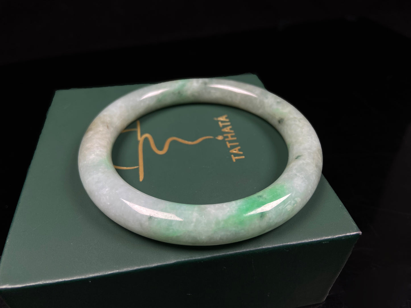 A pale white cyan base with lively green accents  jadeite bangle.