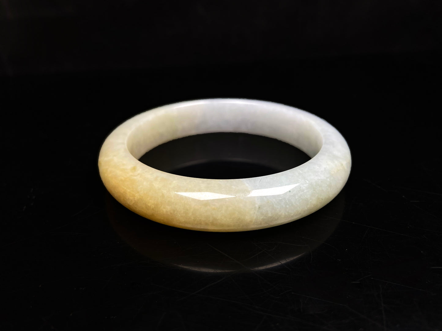 A creamy gold veil jadeite bangle.