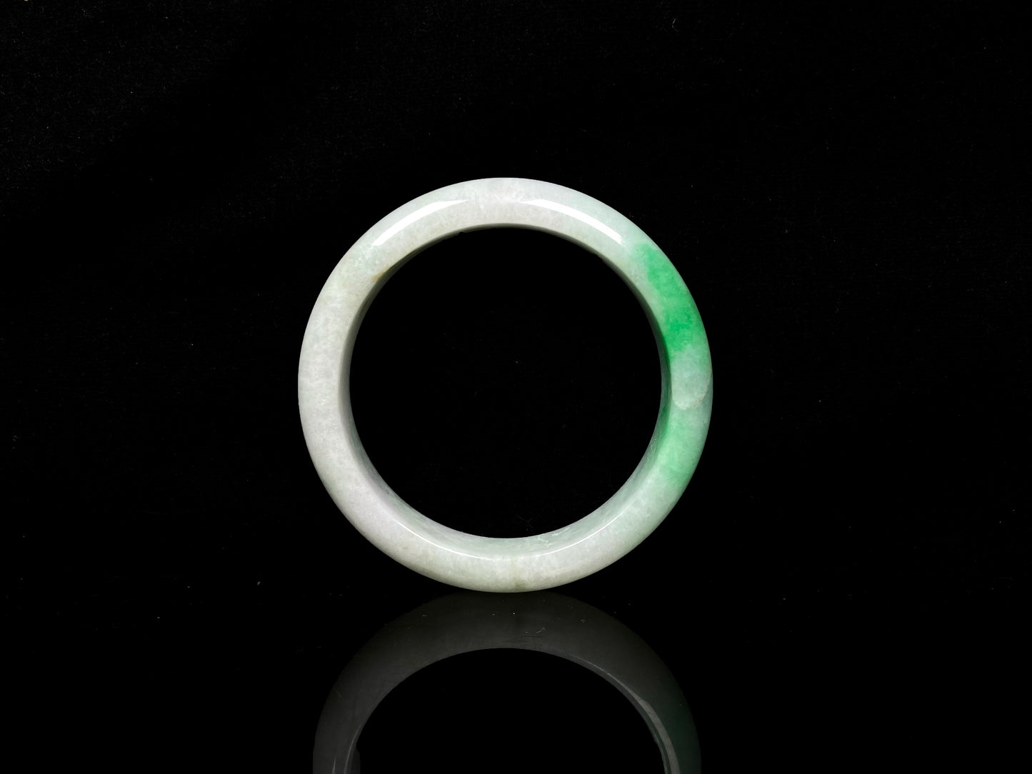 A white base with sunlit green jadeite bangle.