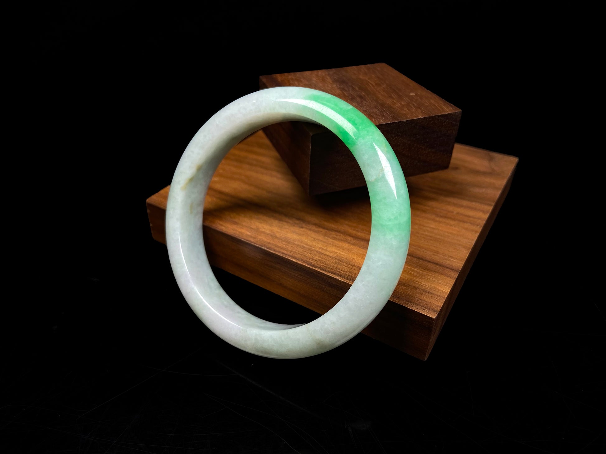 A white base with sunlit green jadeite bangle.
