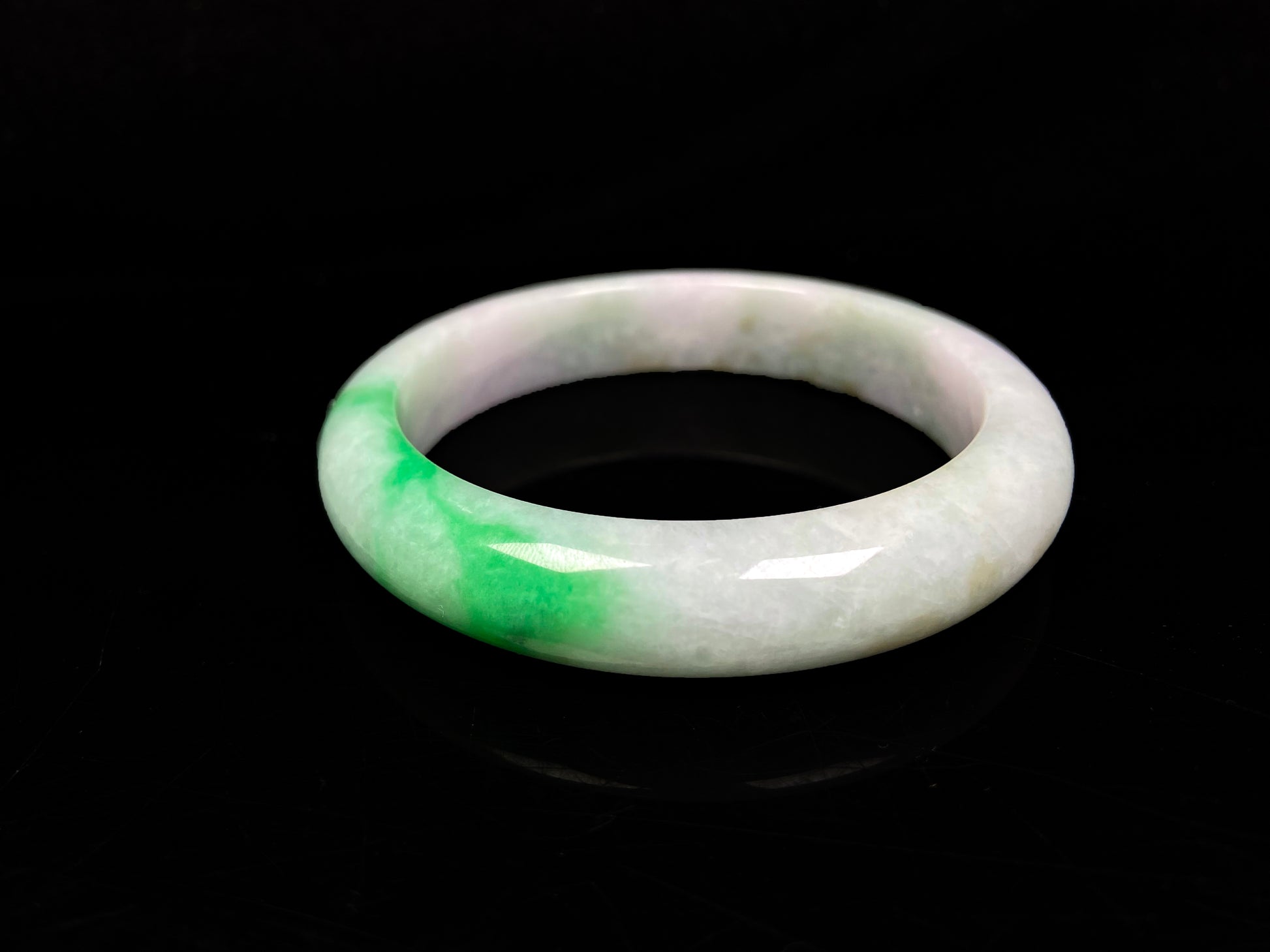 A bright green cloud white jadeite bangle.
