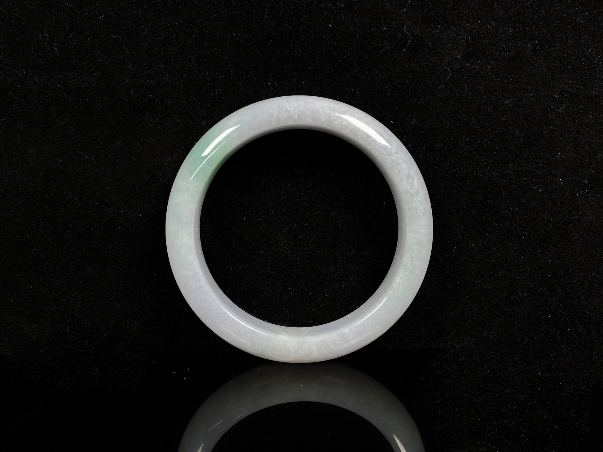 A violet white with green jadeite bangle.