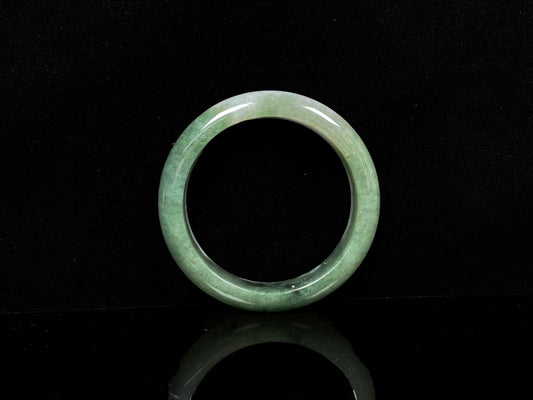 A oily deep green jadeite bangle.