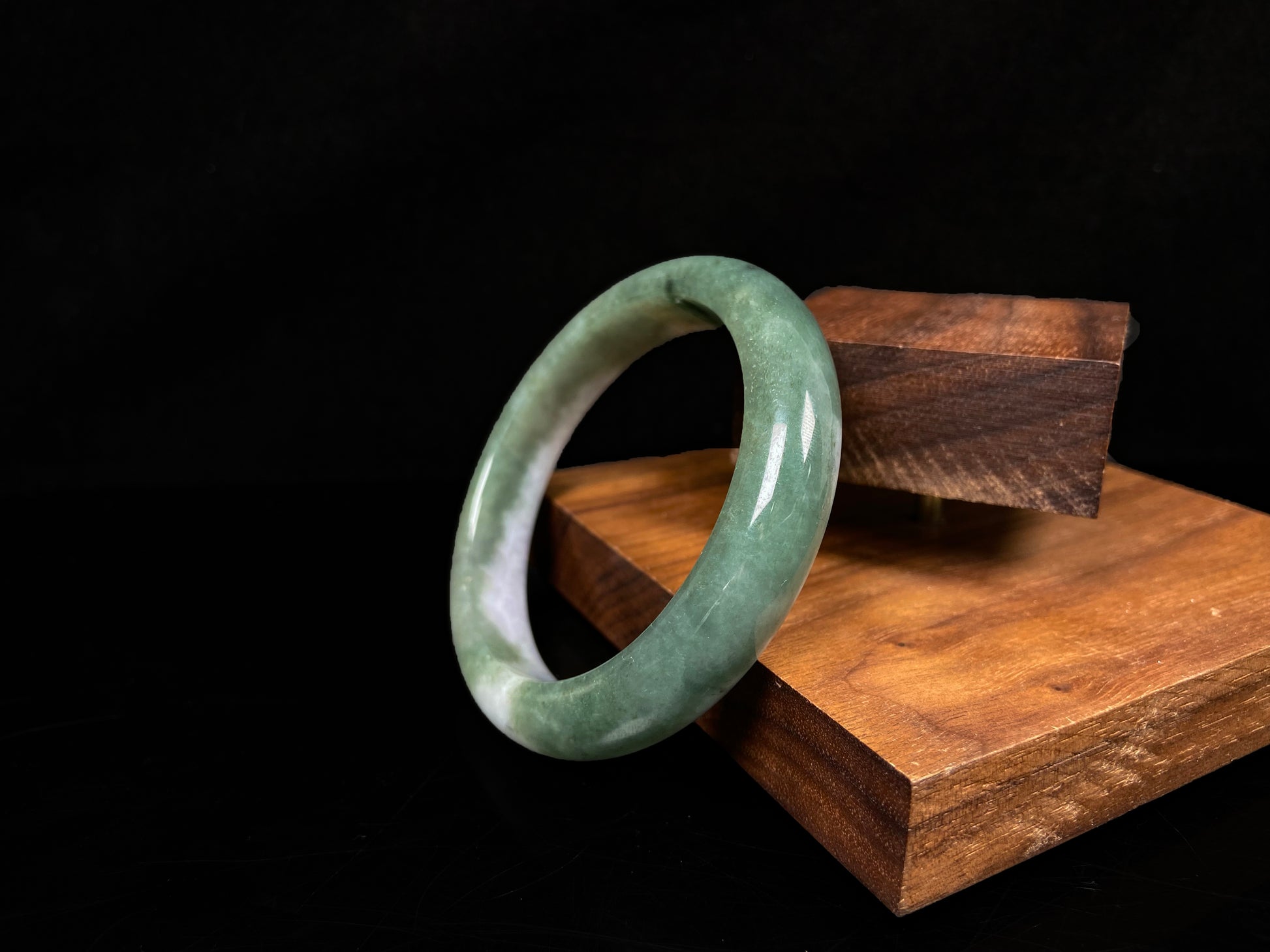 A oily deep green jadeite bangle.