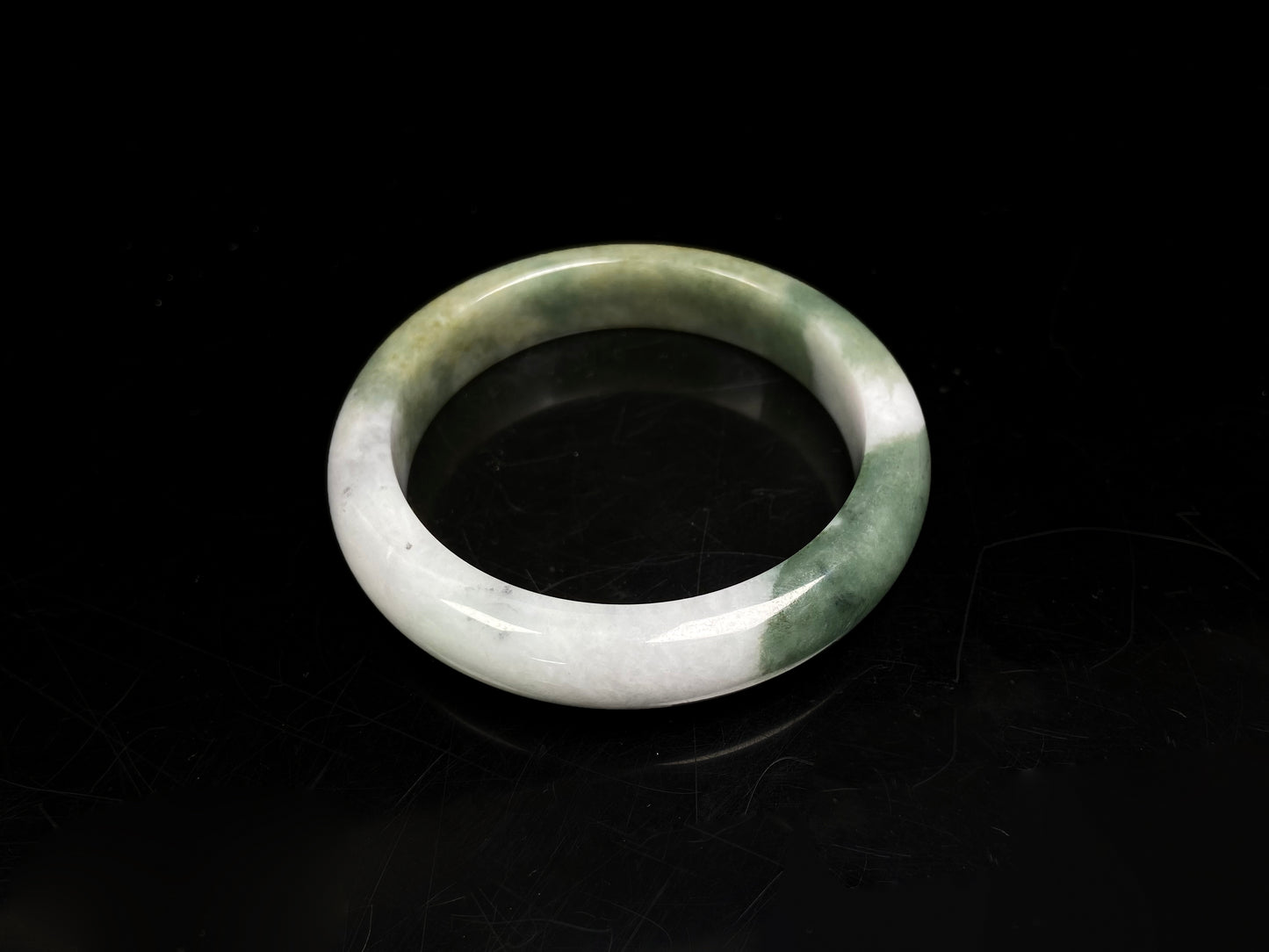 A verdant gold silken white  jadeite bangle.