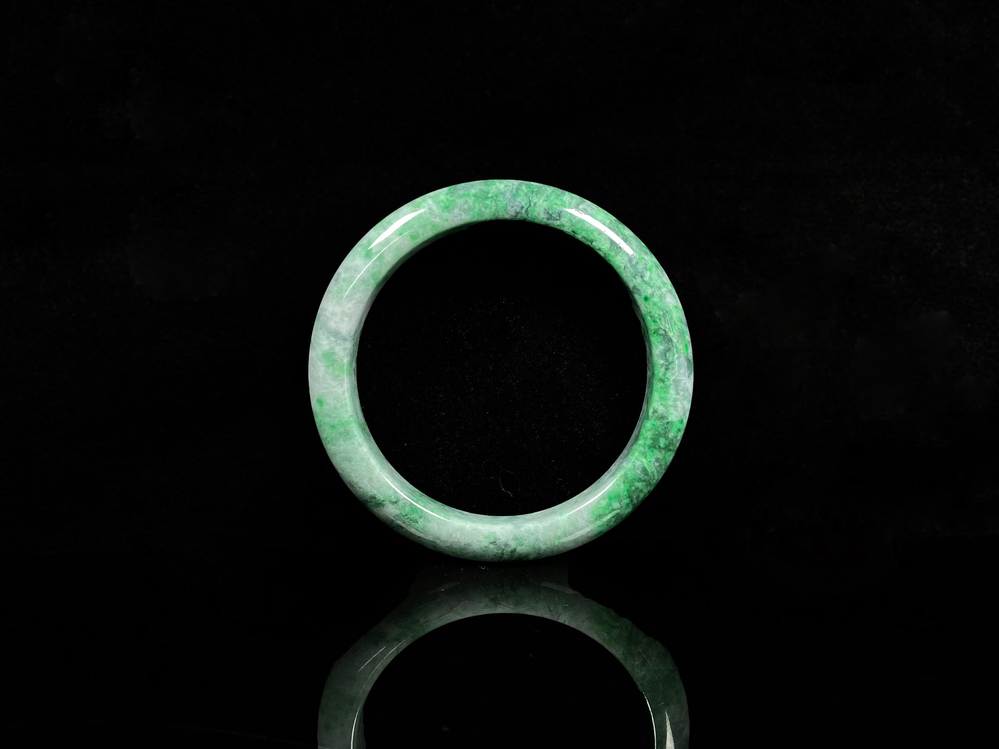 A white-base green-pattern jadeite bangles.