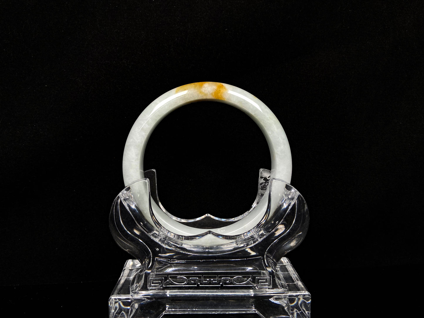 A amber touched snow jadeite bangle.