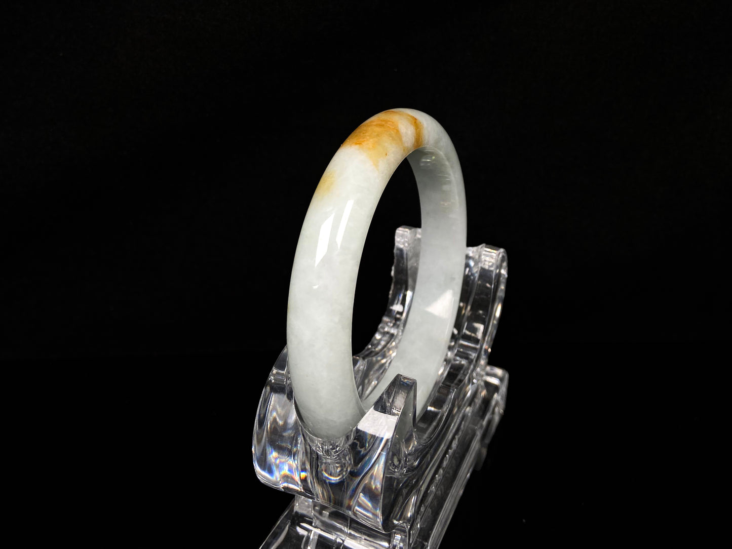 A amber touched snow jadeite bangle.