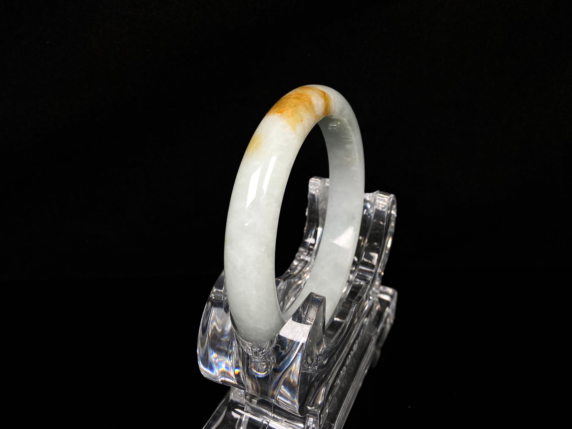 A amber touched snow jadeite bangle.