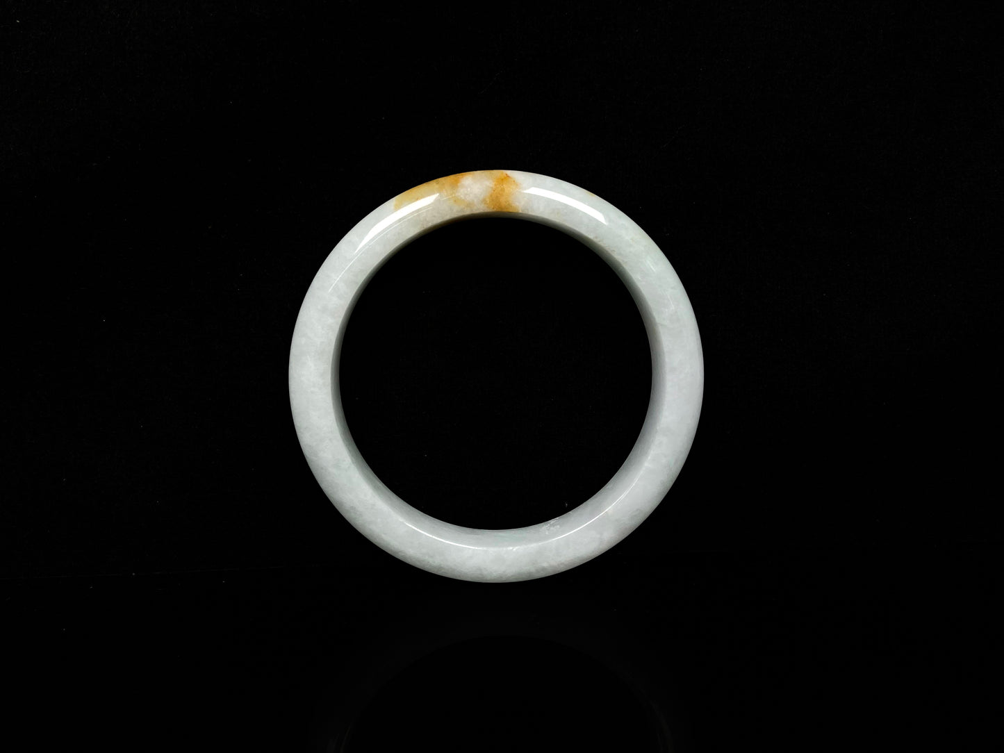 A amber touched snow jadeite bangle.