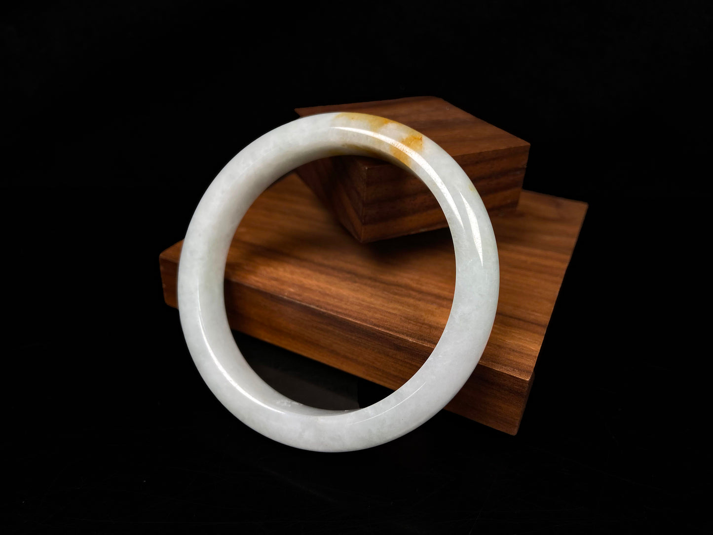 A amber touched snow jadeite bangle.