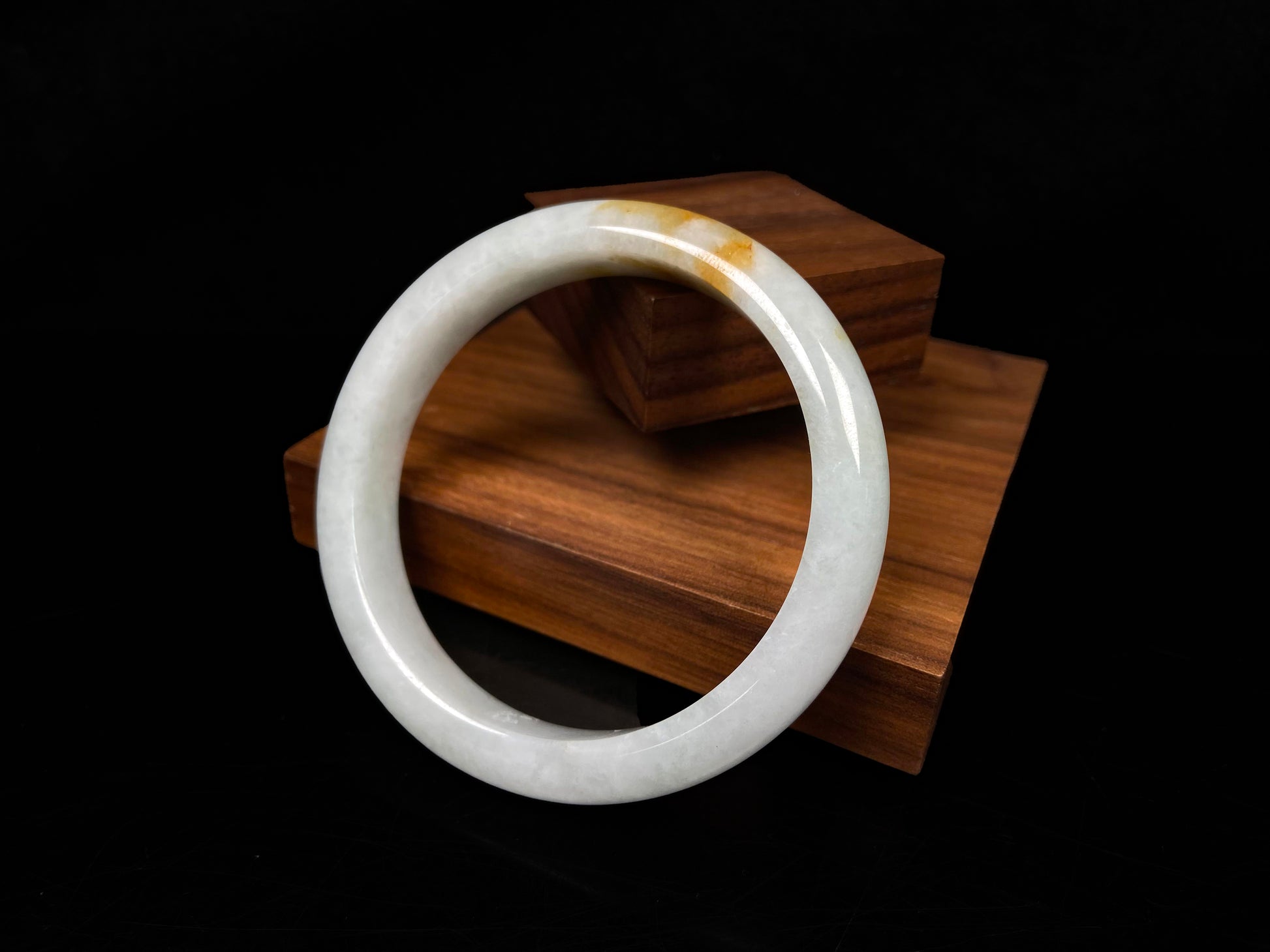 A amber touched snow jadeite bangle.