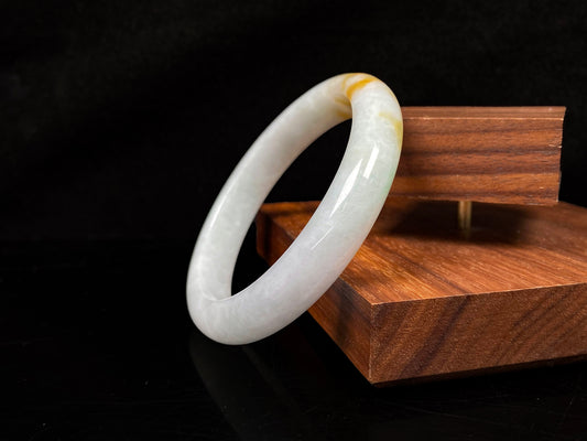A amber touched snow jadeite bangle.