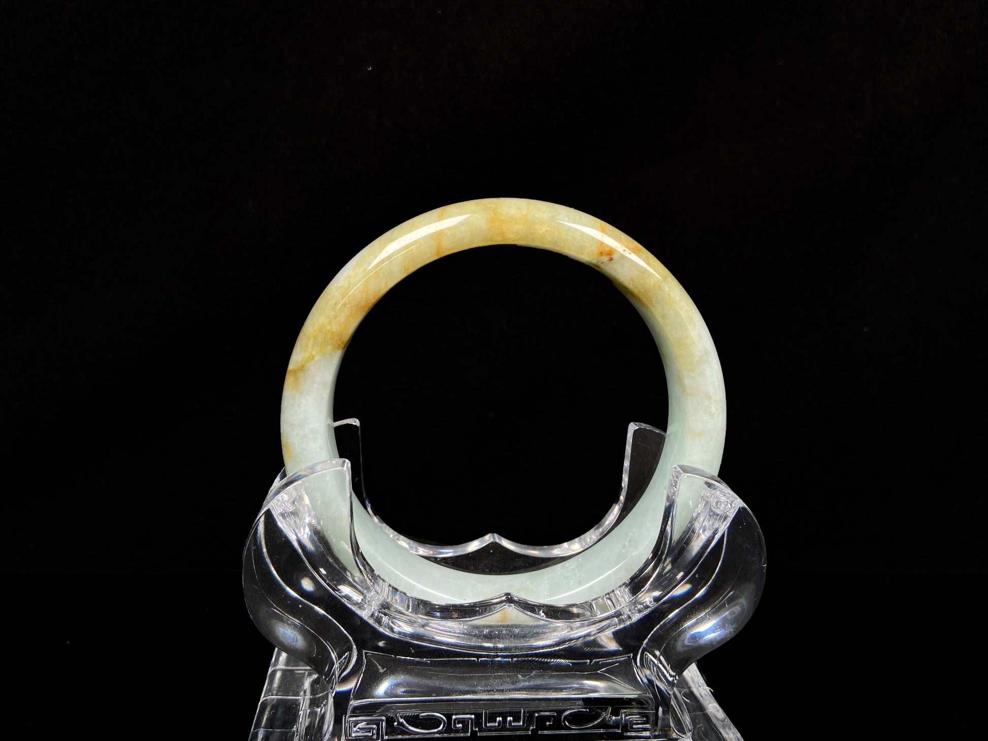 A soft celadon with amber swirls jadeite bangle.