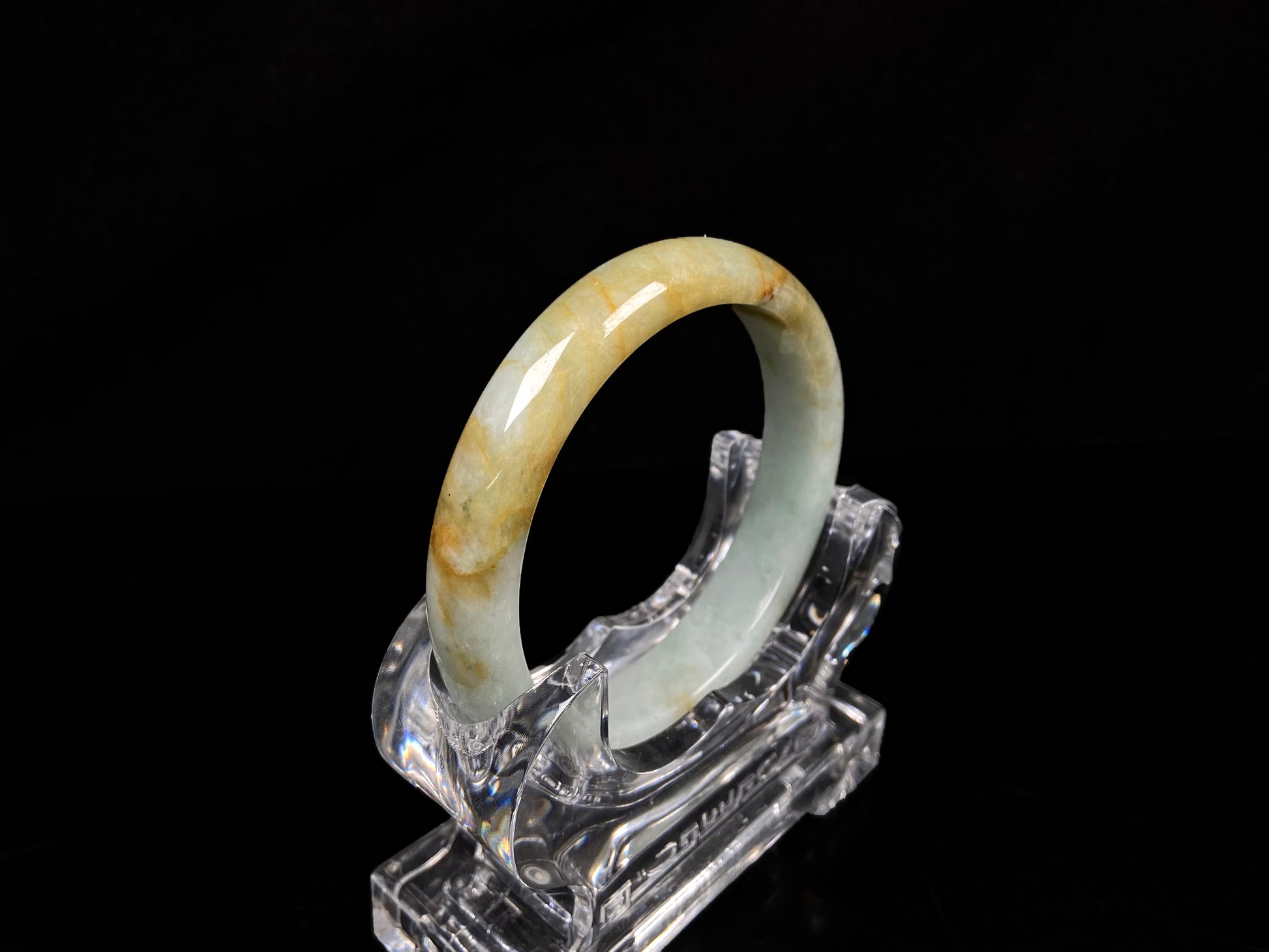 A soft celadon with amber swirls jadeite bangle.