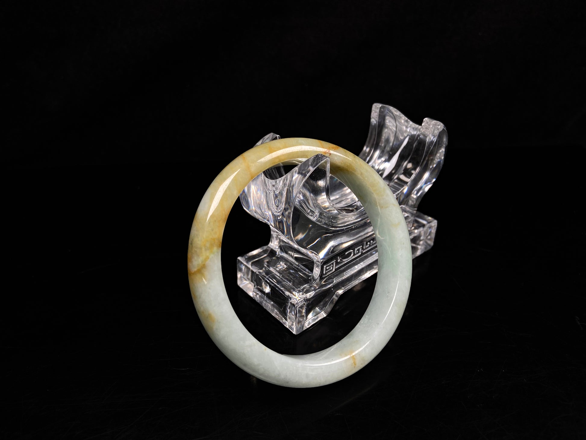 A soft celadon with amber swirls jadeite bangle.
