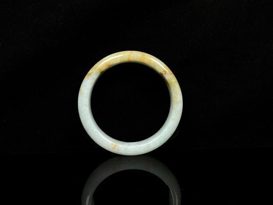 A soft celadon with amber swirls jadeite bangle.
