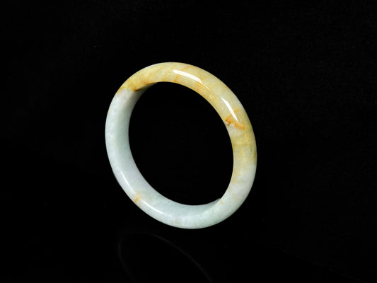 A soft celadon with amber swirls jadeite bangle.