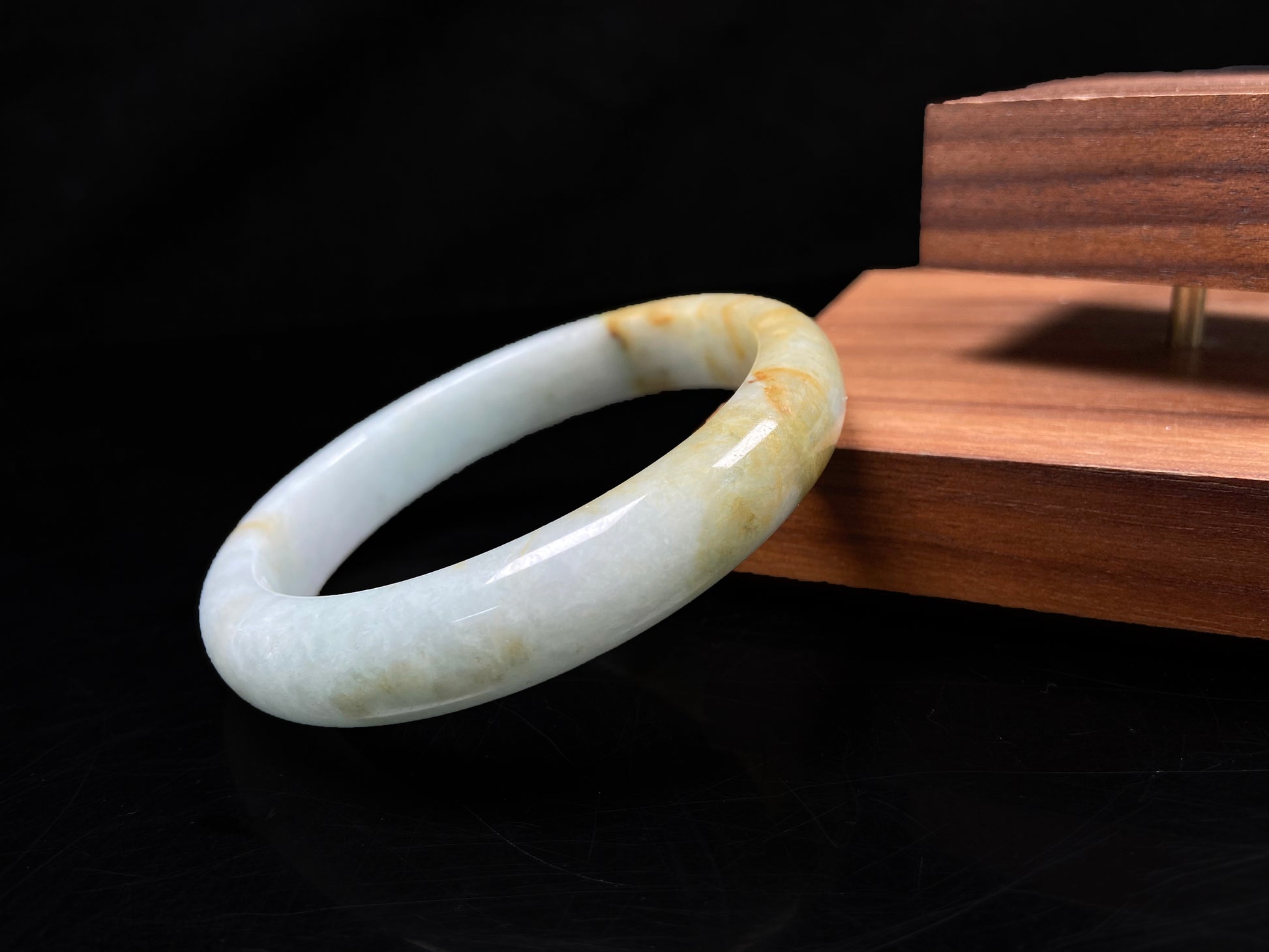 A soft celadon with amber swirls jadeite bangle.