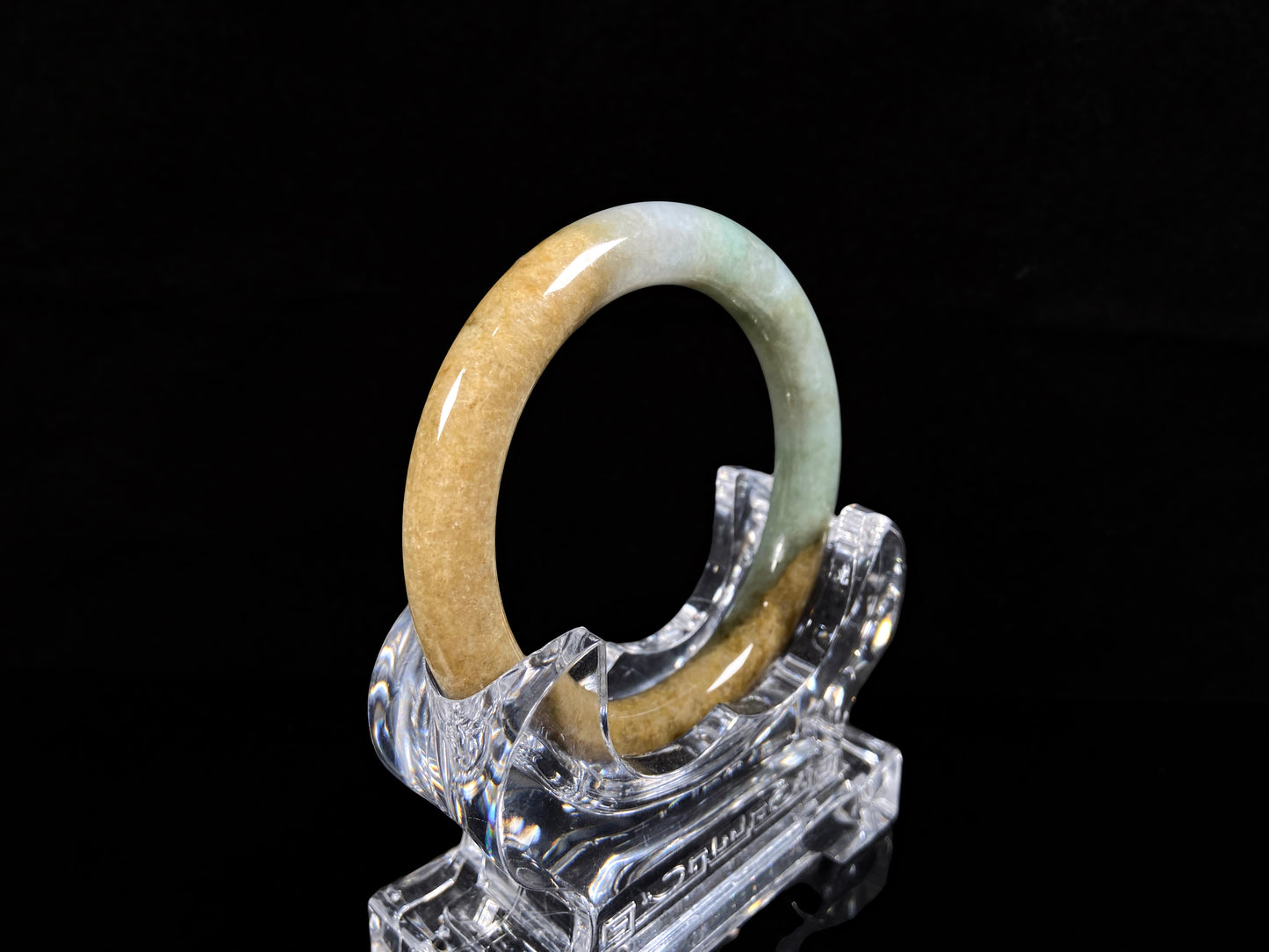 A golden sand and green mist jadeite bangle.
