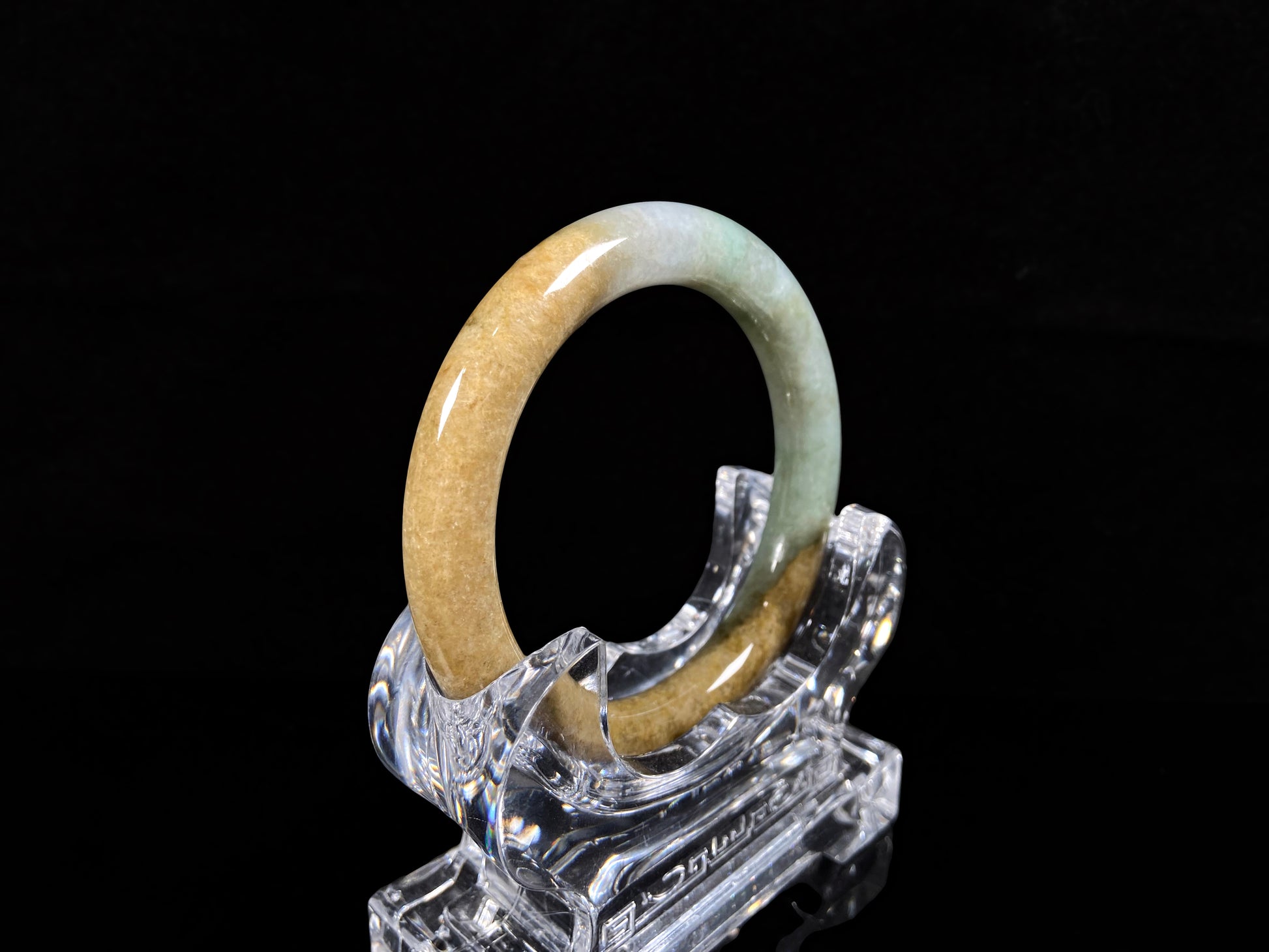 A golden sand and green mist jadeite bangle.