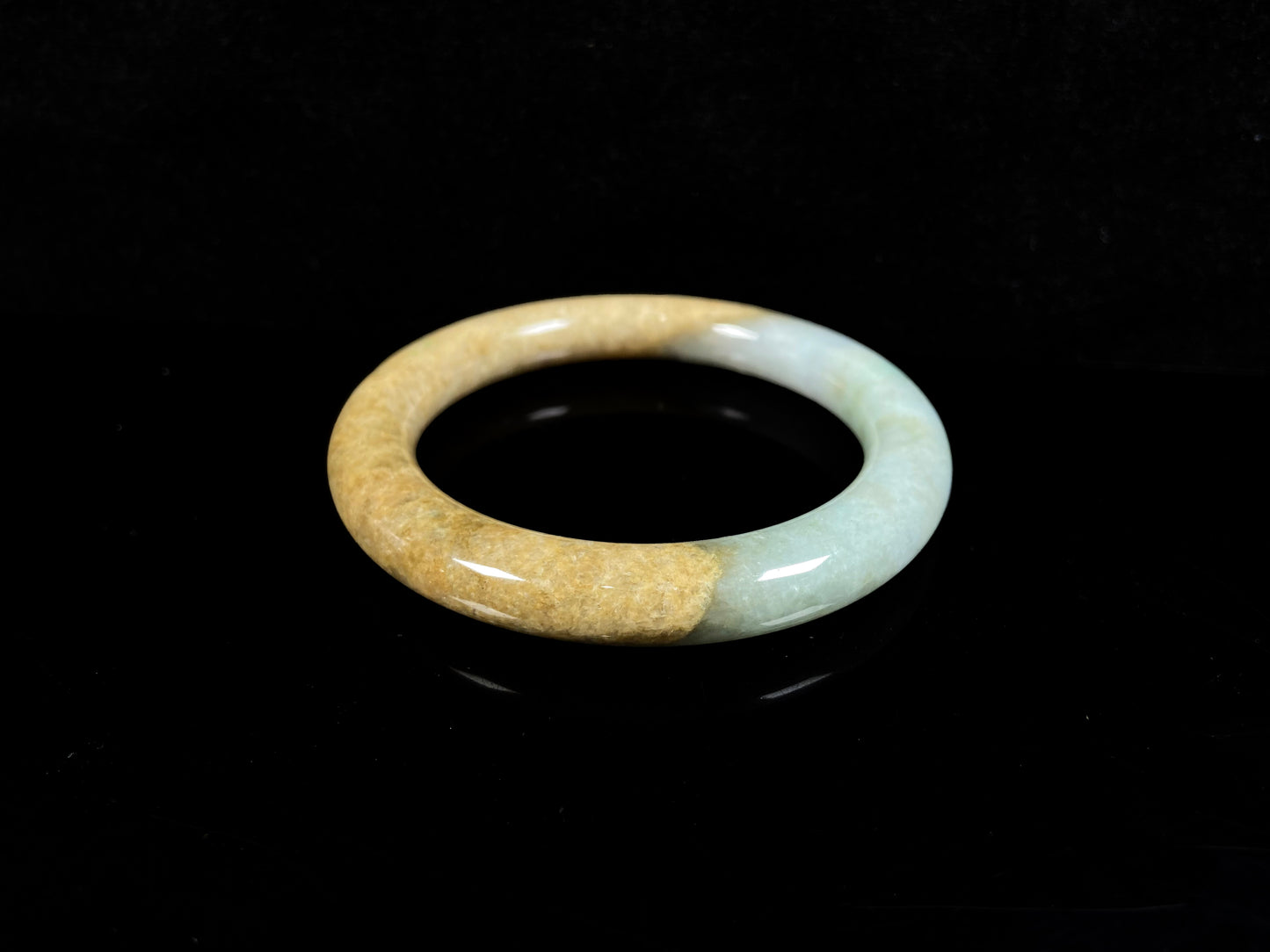 A golden sand and green mist jadeite bangle.