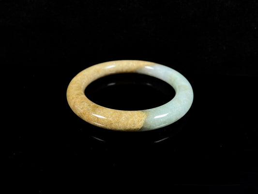 A golden sand and green mist jadeite bangle.