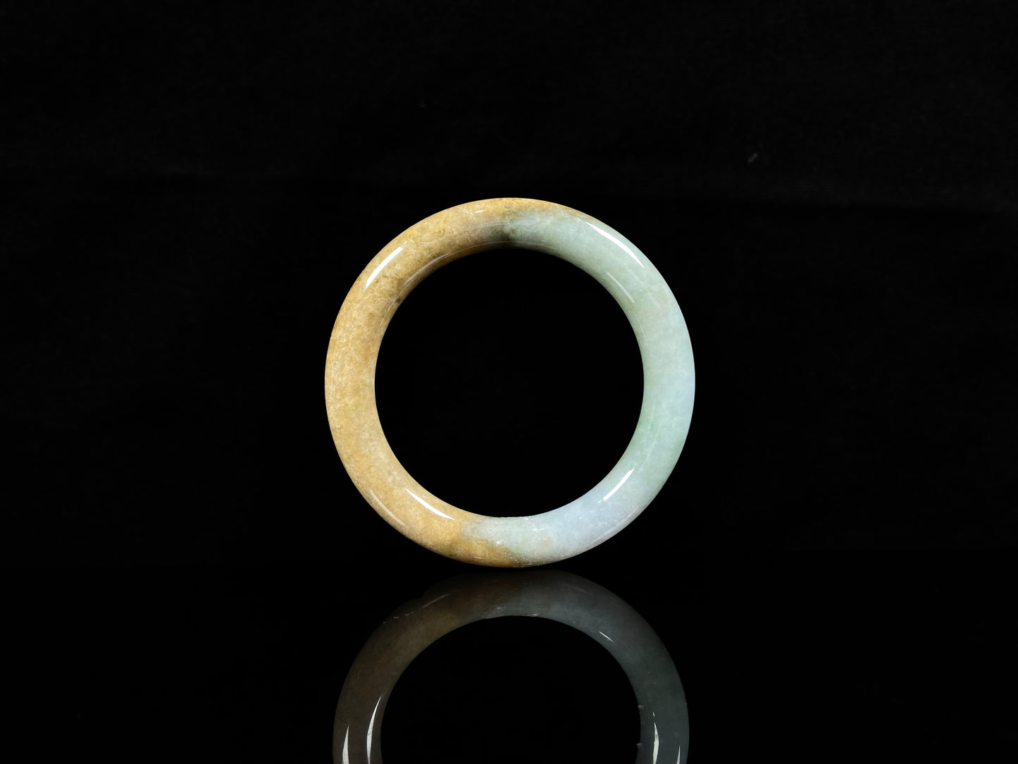 A golden sand and green mist jadeite bangle.