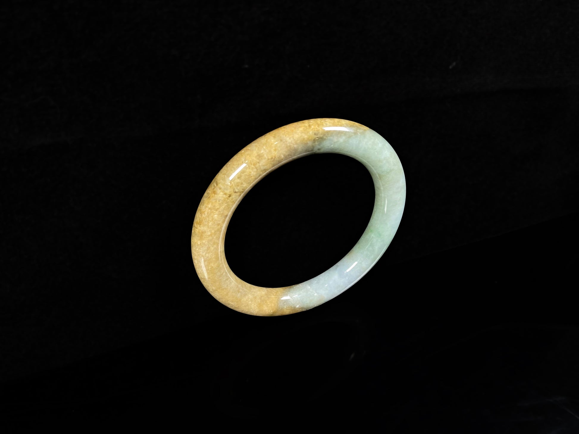 A golden sand and green mist jadeite bangle.