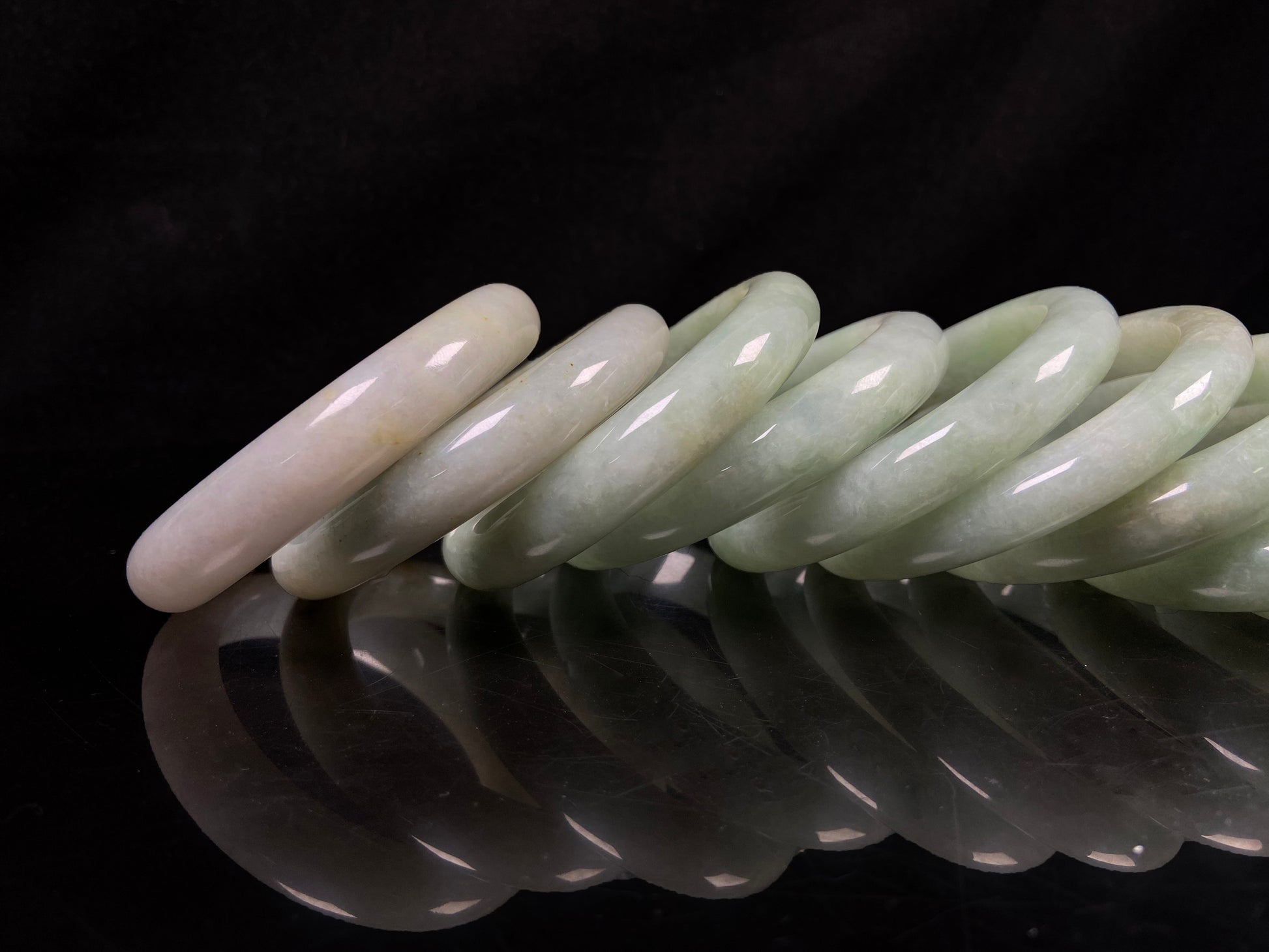 A willow bud green glow jadeite bangle group.