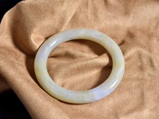 White jade bracelet on a beige fabric background
