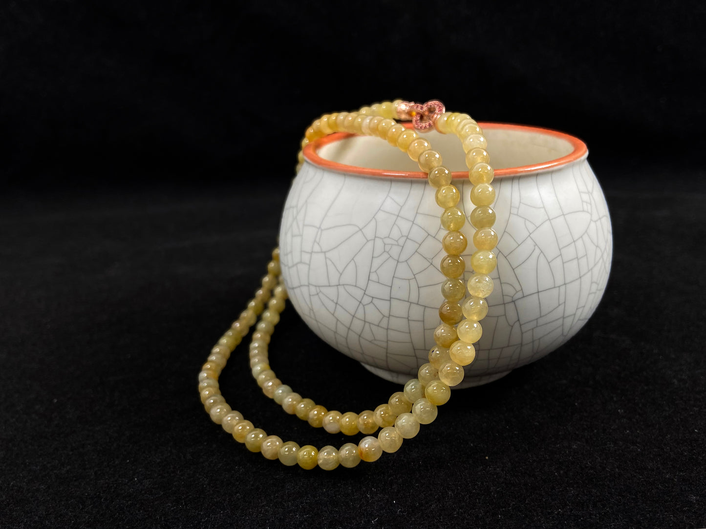 A semi transparent yellow jade bead strand connected by alloy end caps.