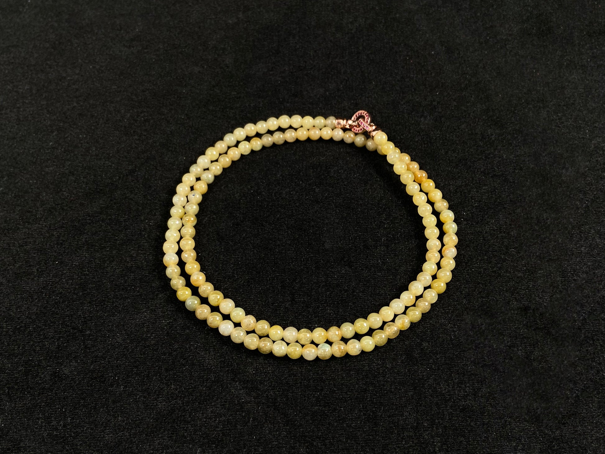 A semi transparent yellow jade bead strand connected by alloy end caps.