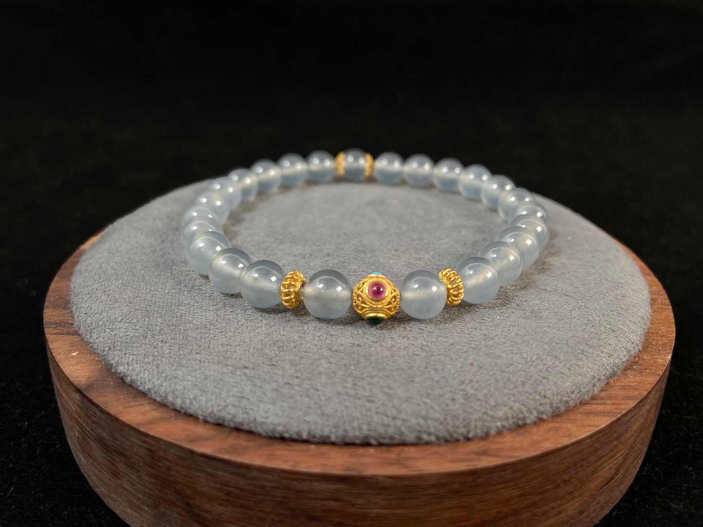 This bracelet combines icy jadeite beads with a hollow 18K gold center bead.