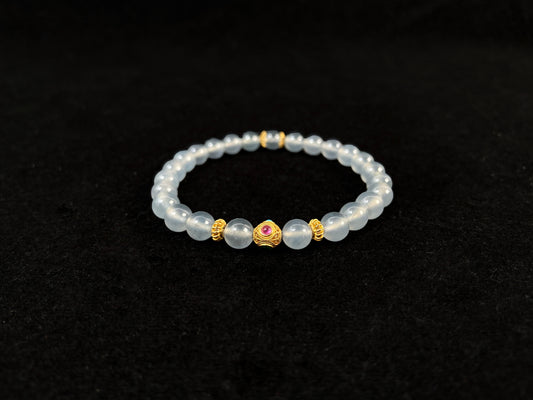 This bracelet combines icy jadeite beads with a hollow 18K gold center bead.
